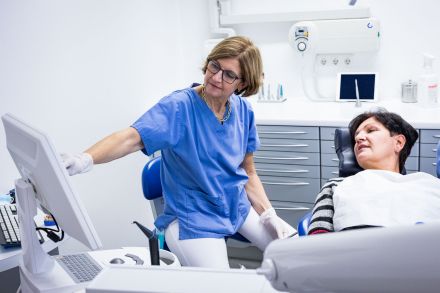 Zahnärztin Dr. Christiane Ternes erläutert einen Befund anhand einer Bildschirmdarstellung