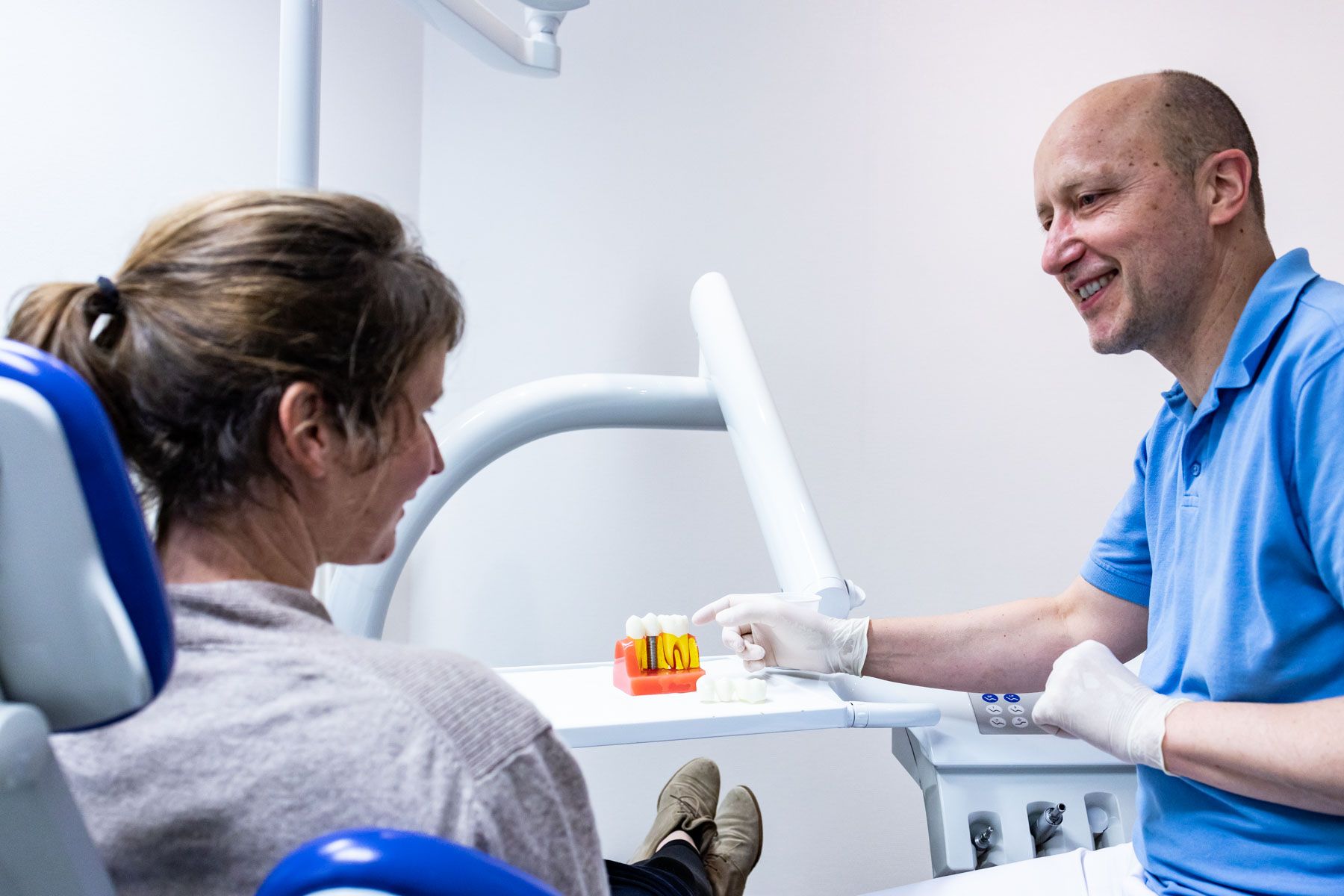 Zahnarzt berät Patientin im Hinblick auf ein Implantat